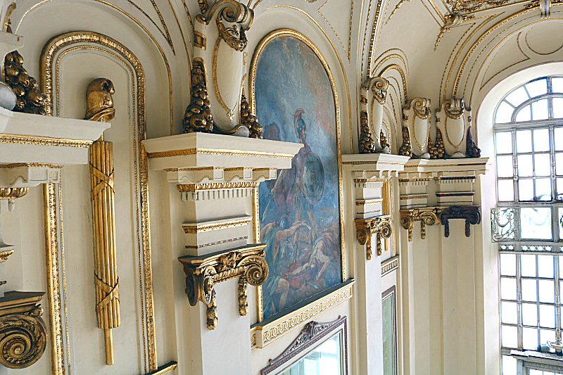 the walls are ornamented with golden embossments and the Phrygian caps