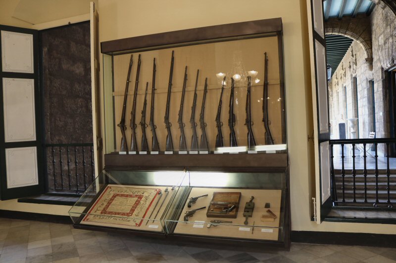 In Sala de Armamento Español, a small collection of various weapons and their equipment, used by the Spanish forces in Cuba, are exhibited in showcases. Miscellaneous weapons, from the primitive flintlock rifle to the modern Mauser, bayonets, pistols, bullets, and a military training handkerchief are the exhibited pieces in the room.